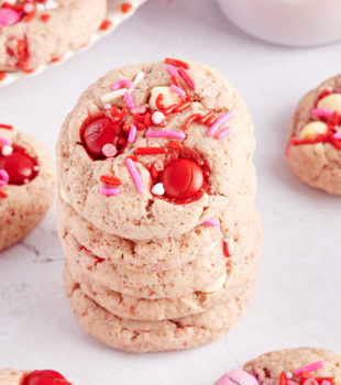 stack of five Strawberry M&M Cookies surrounded by more cookies