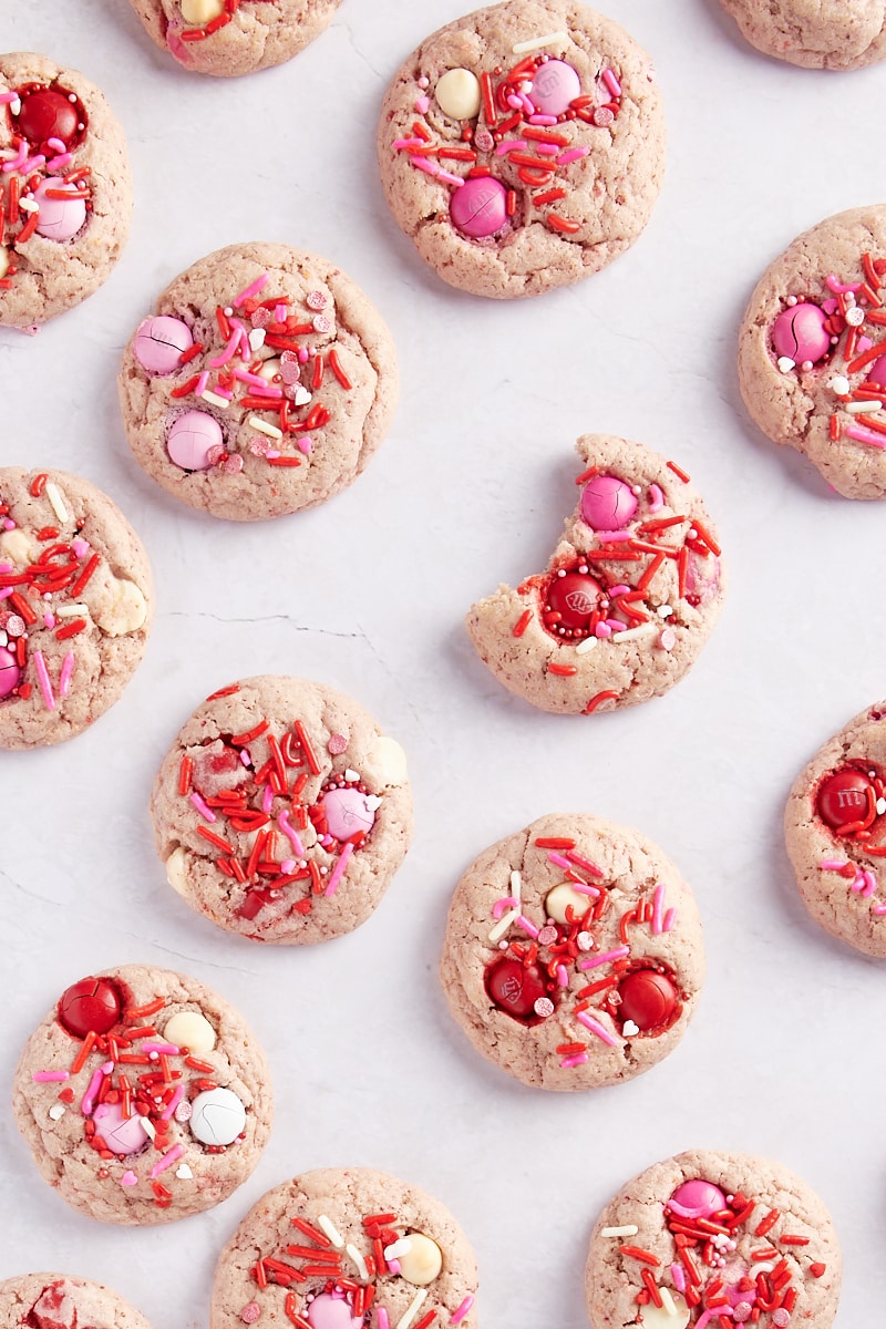 overhead view of Strawberry M&M Cookies scattered on a marble surface