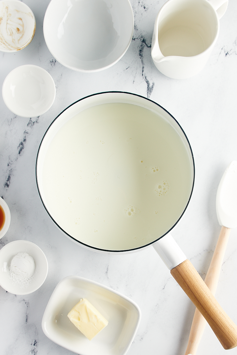 overhead view of milk, sugar, cornstarch, vanilla bean paste, and salt in a saucepan