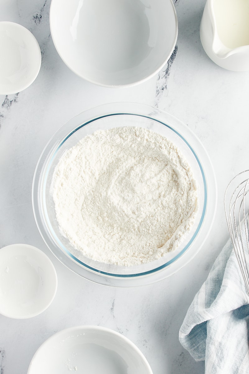 overhead view of whisked flour, sugar, baking powder, and salt in a glass mixing bowl