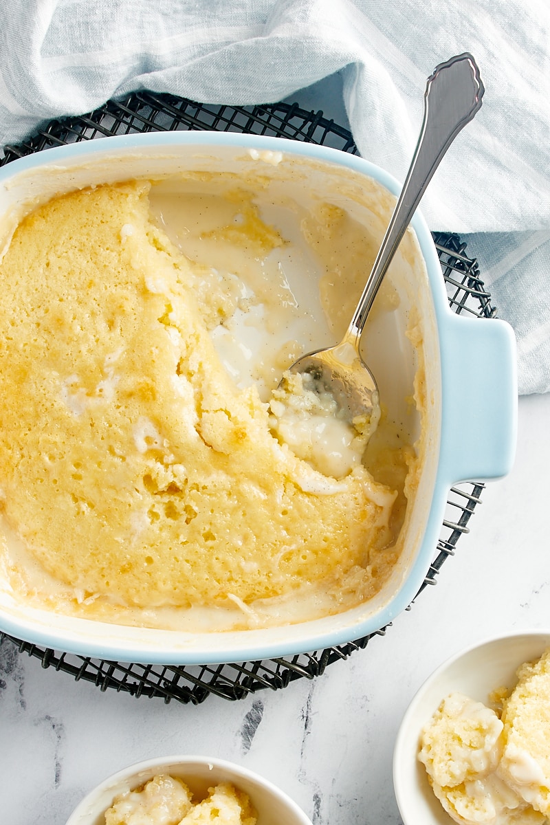 overhead view of Vanilla Pudding Cake in a baking pan with a few servings missing