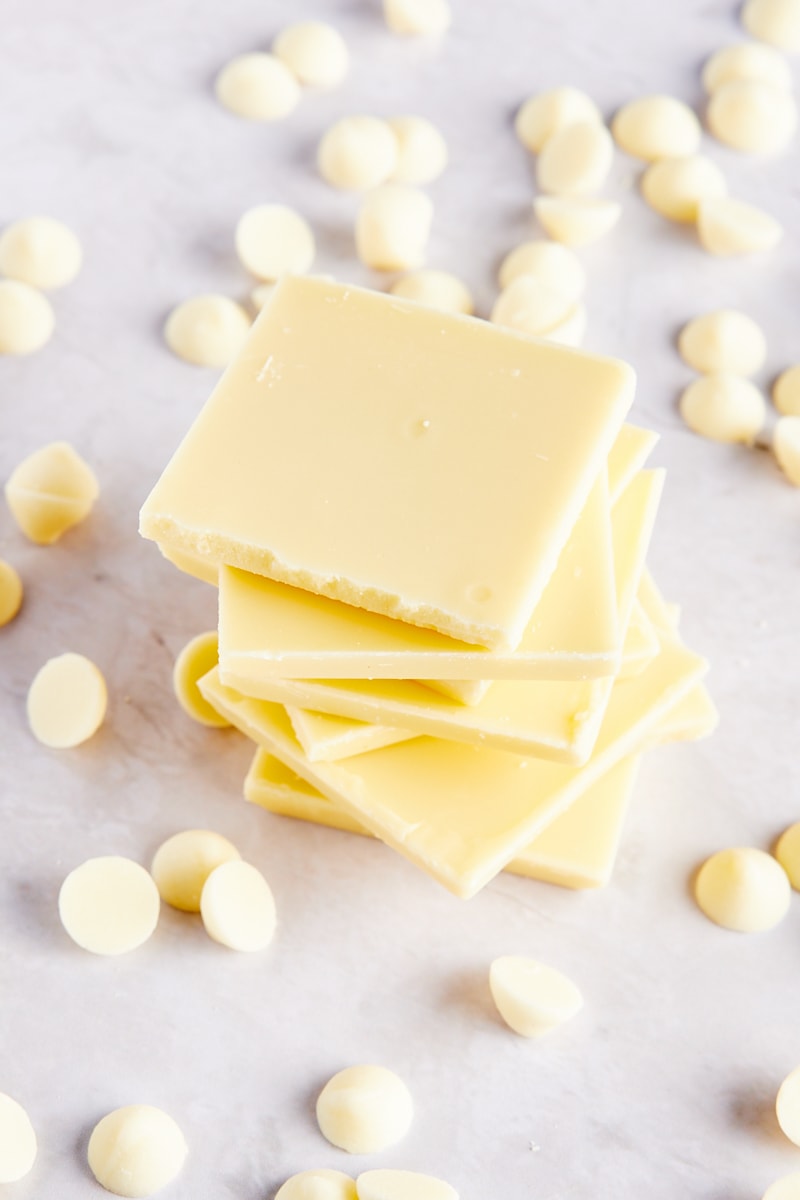 stack of white chocolate pieces surrounded by white chocolate chips
