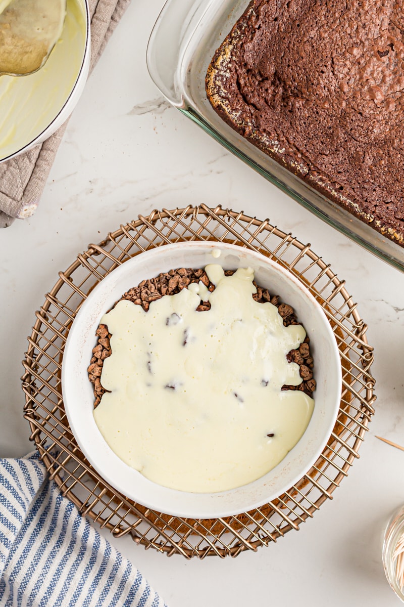 Overhead view of butter and cream added to mixing bowl of chopped chocolate