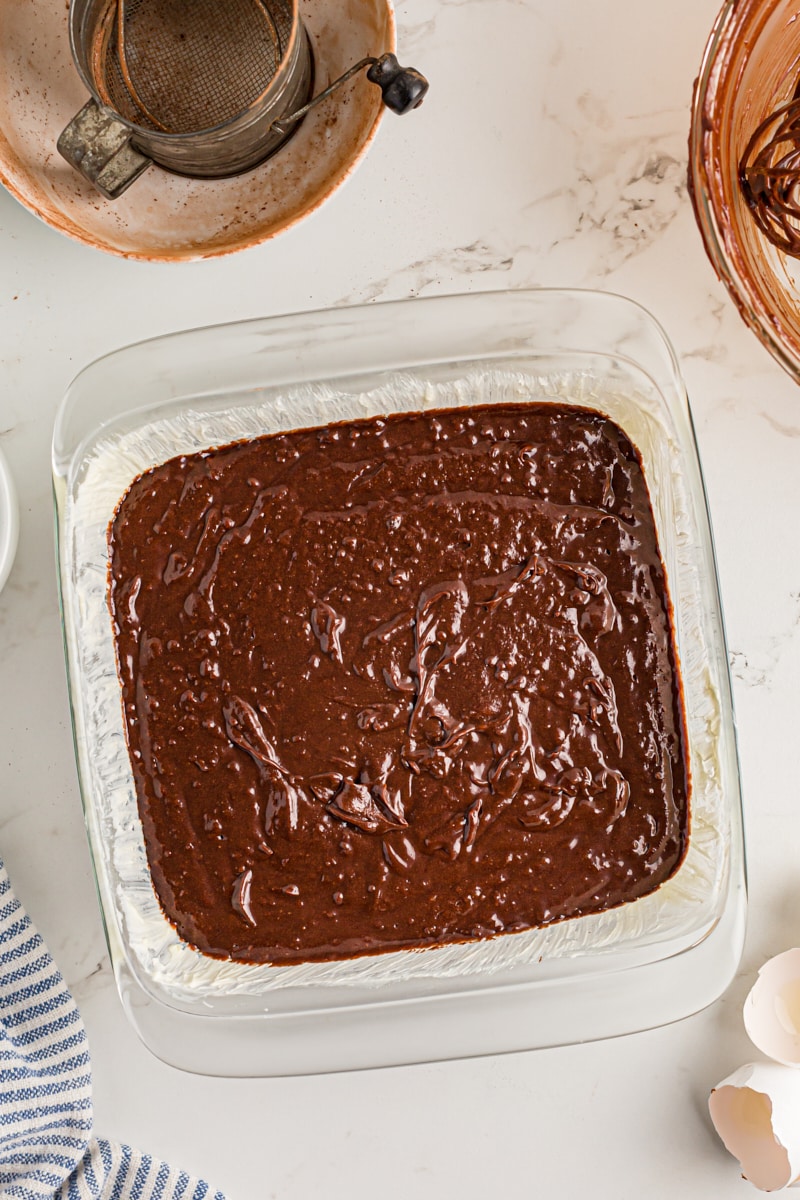 Overhead view of brownie batter in glass baking pan