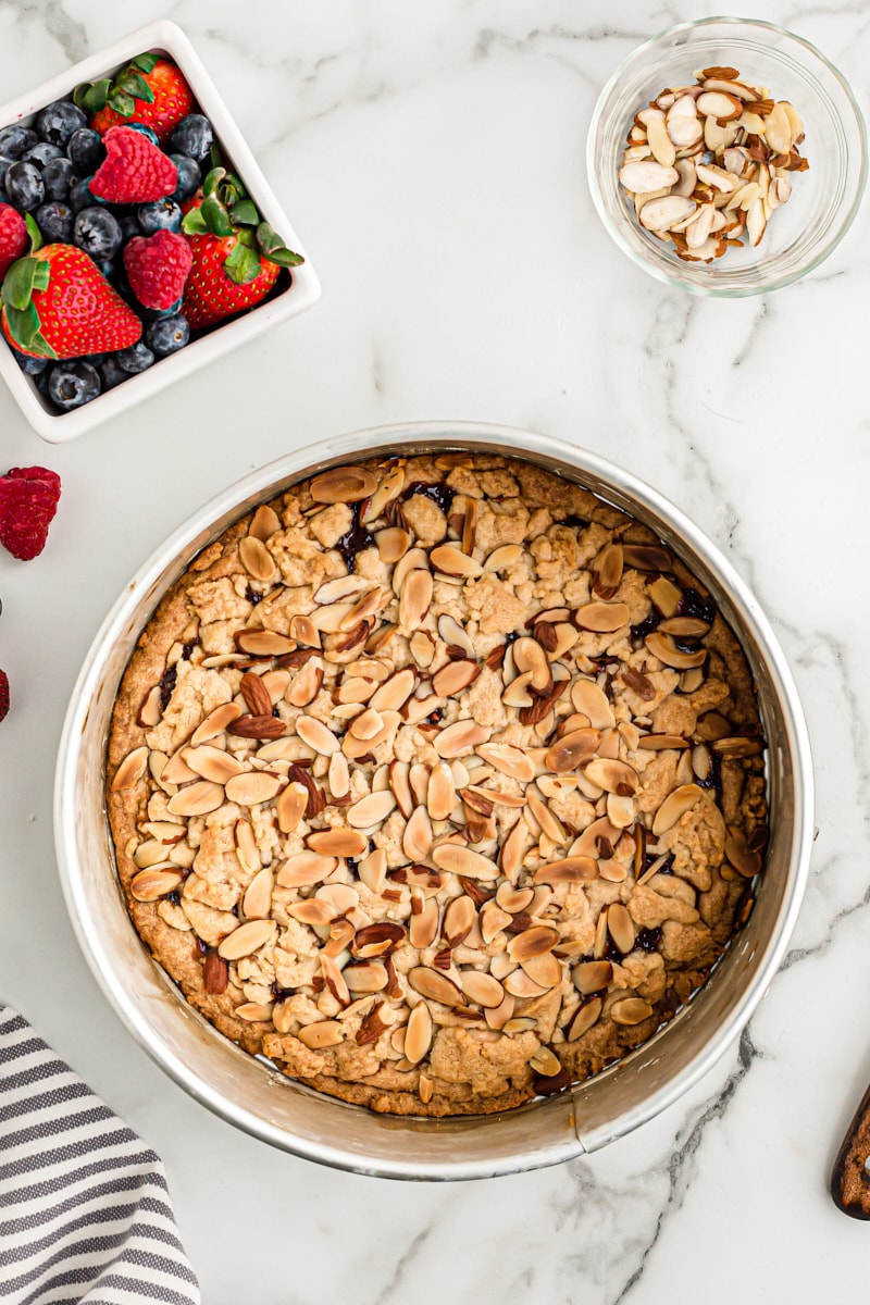 overhead view of freshly baked Italian Jam Crostata in a springform pan on a marble surface