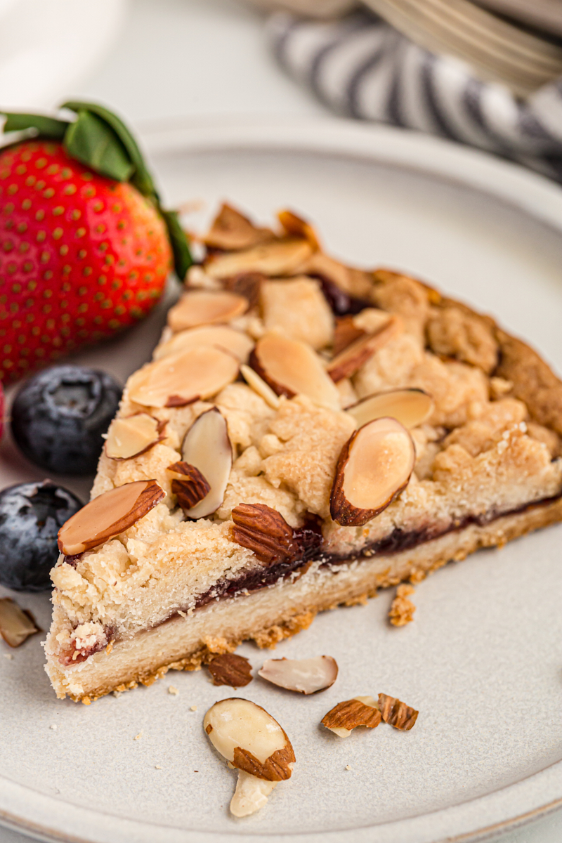 slice of Italian Jam Crostata on a white plate with fresh berries