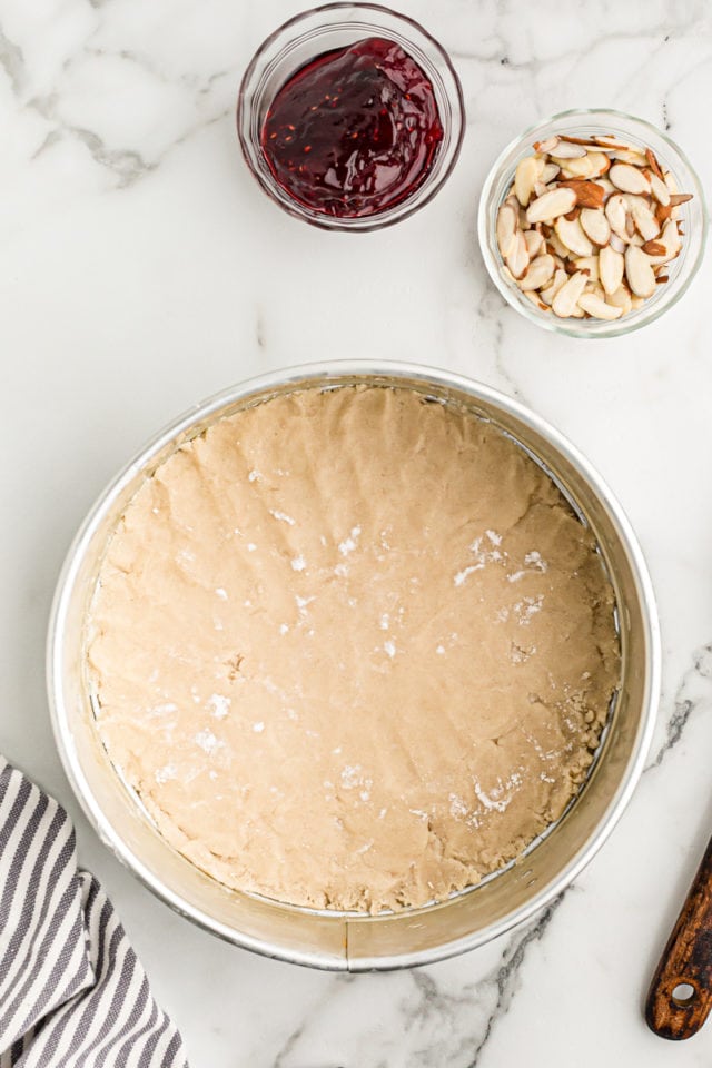 overhead view of crostata crust pressed into the bottom of a springform pan