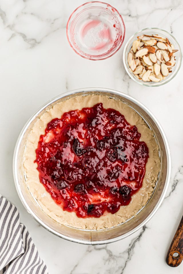 overhead view of jam spread over crostata crust in a springform pan