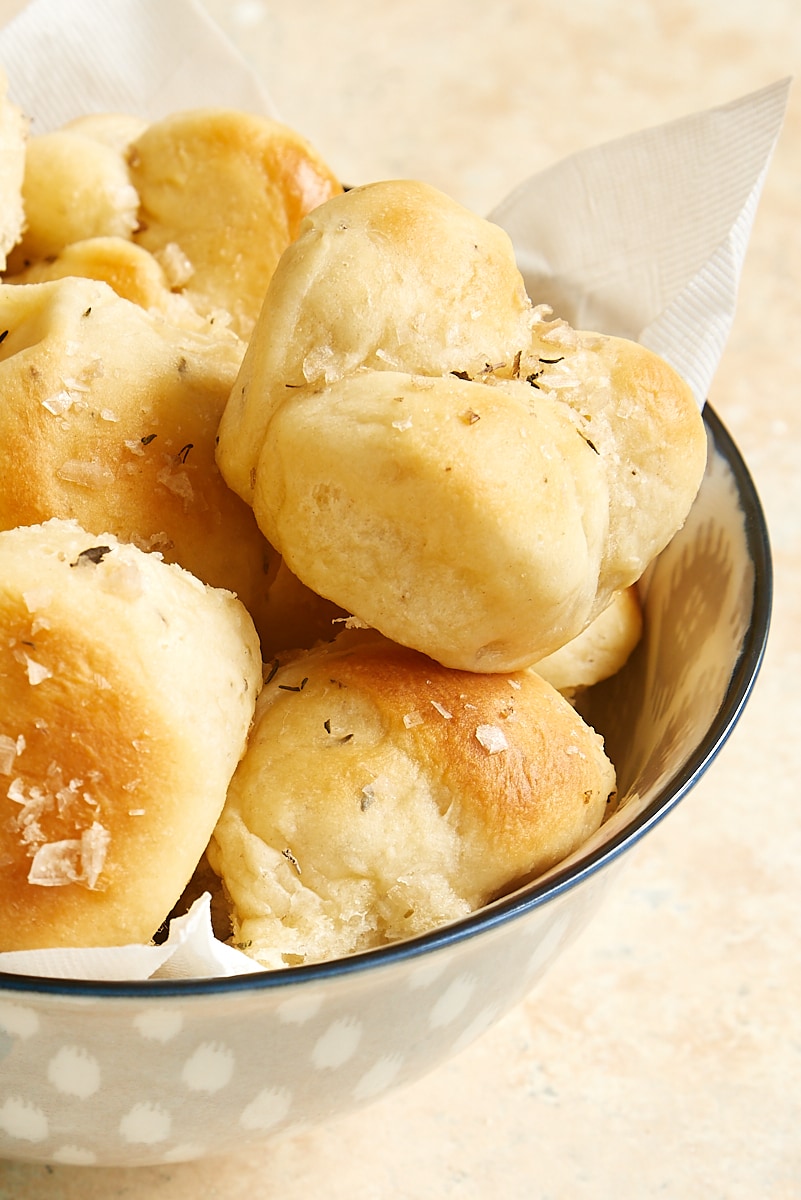 a lined gray bowl filled with brown and serve rolls