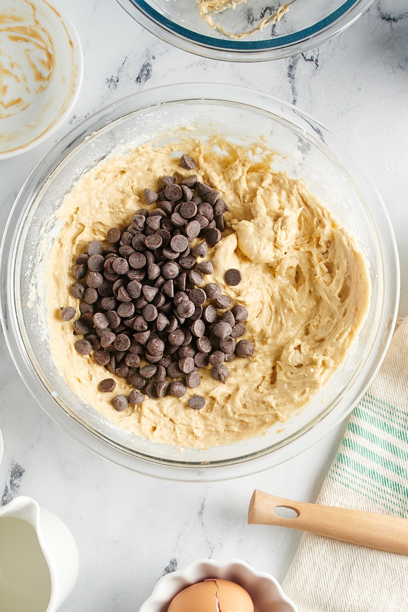 Overhead view of chocolate chips added to batter in mixing bowl