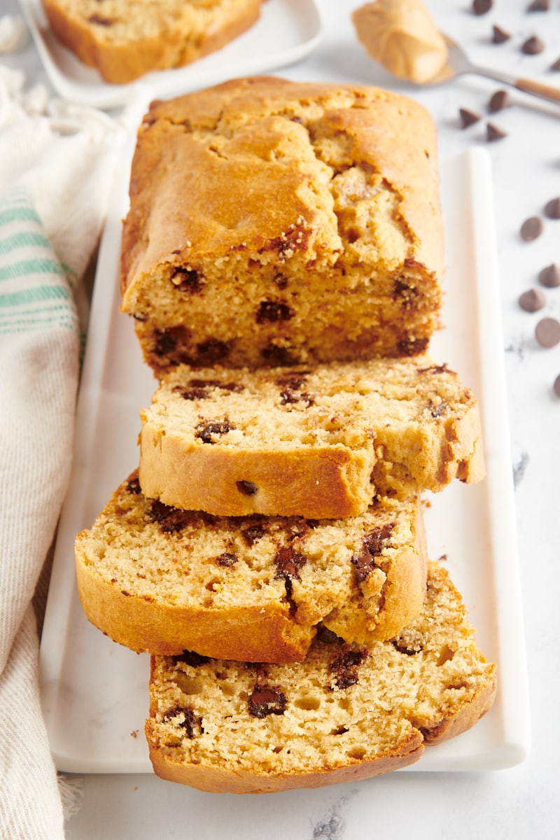 Chocolate chip peanut butter bread on platter with 3 slices cut