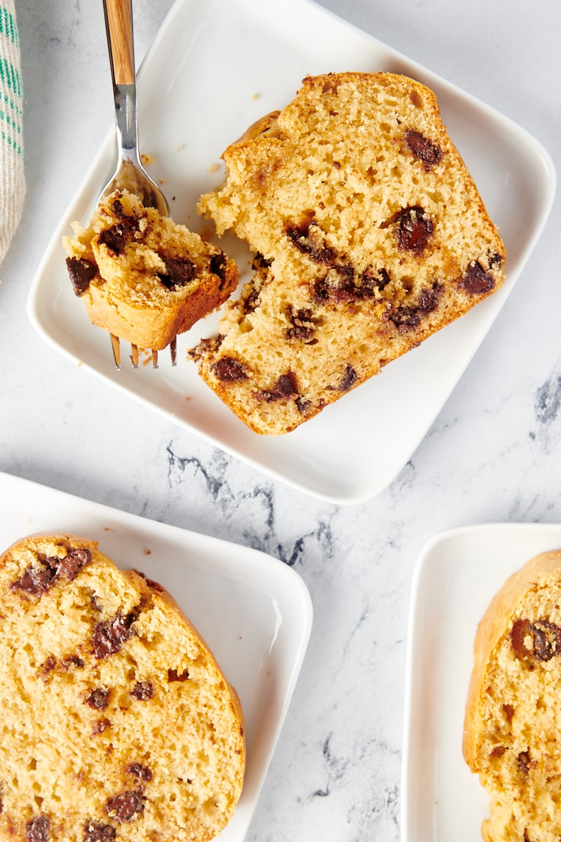 Four slices of chocolate chip peanut butter bread on white square plates