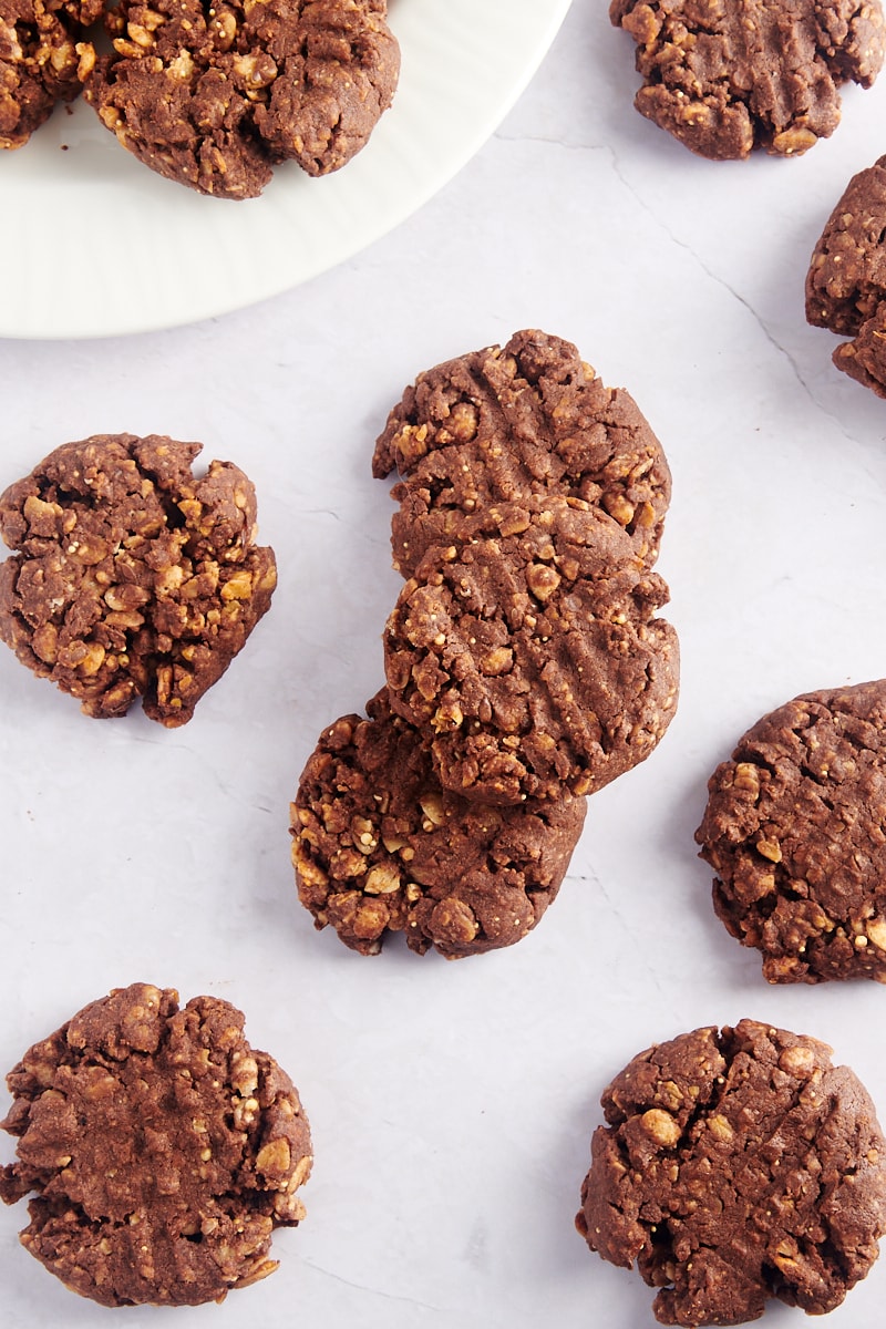 Overhead view of granola cookies on countertop and plate, with some stacked