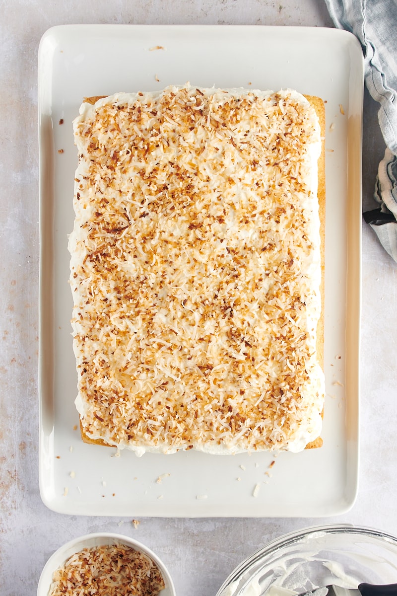 overhead view of coconut sheet cake topped with toasted coconut