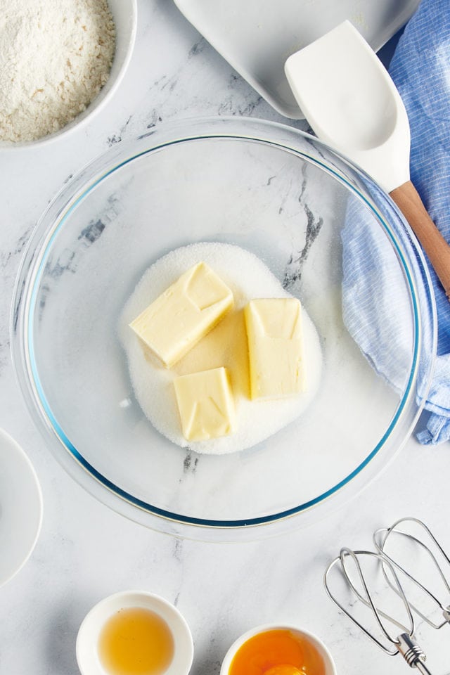 overhead view of butter and sugar in a glass mixing bowl