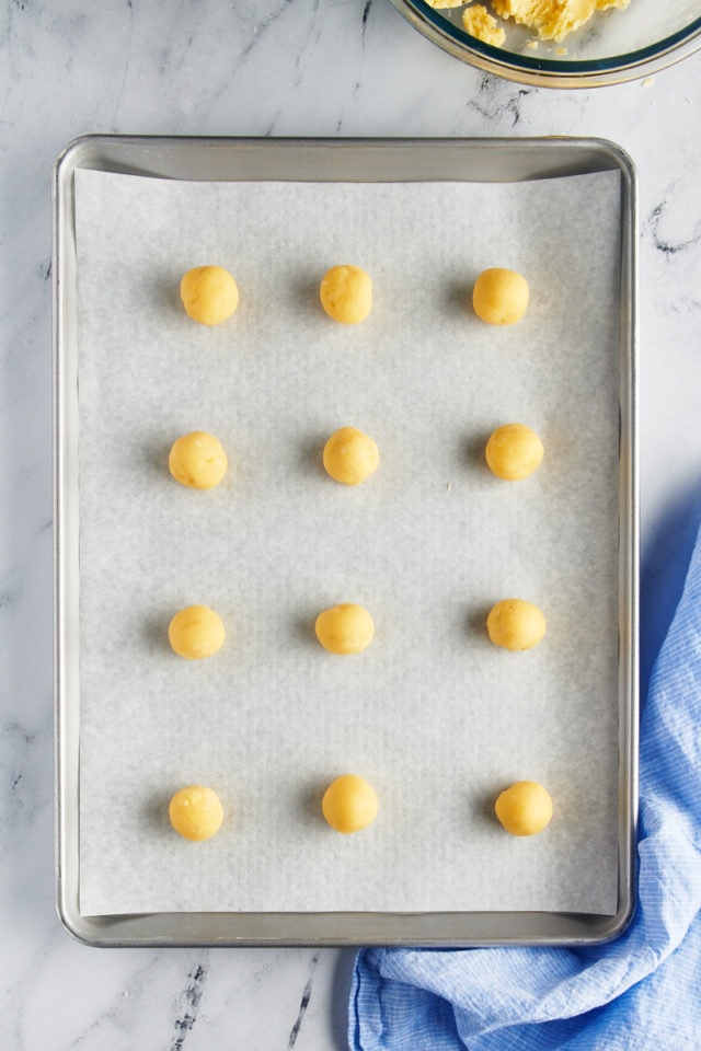 overhead view of portioned cookie dough on a parchment-lined baking sheet