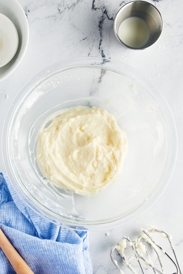 overhead view of mixed vanilla buttercream in a glass mixing bowl