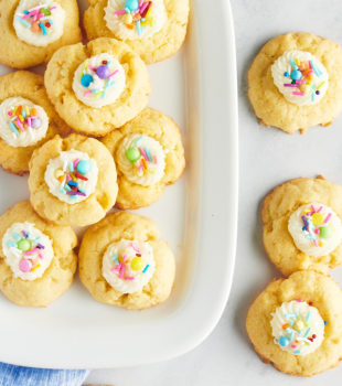 overhead view of Frosting-Filled Thumbprint Cookies on a white tray and a marble surface