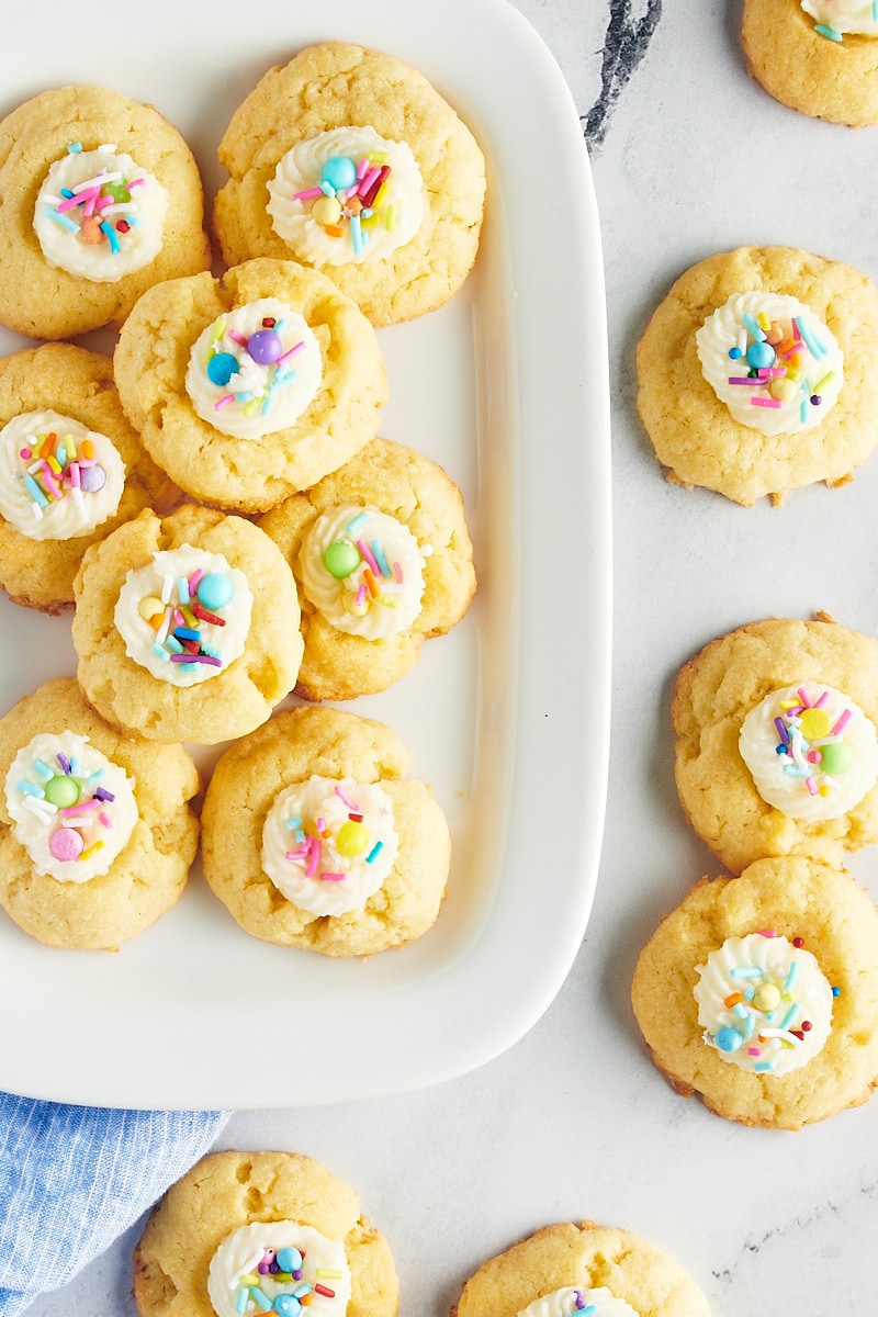 overhead view of Frosting-Filled Thumbprint Cookies on a white tray and a marble surface