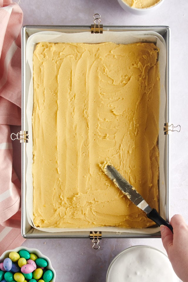 overhead view of sugar cookie dough being spread in a 9x13 pan