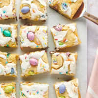 overhead view of sliced M&M Marshmallow Sugar Cookie Bars on white parchment paper