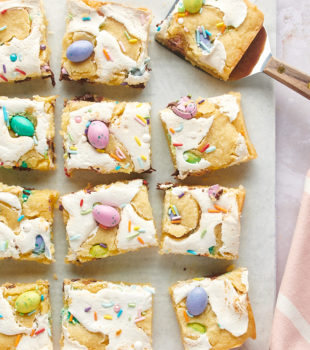 overhead view of sliced M&M Marshmallow Sugar Cookie Bars on white parchment paper