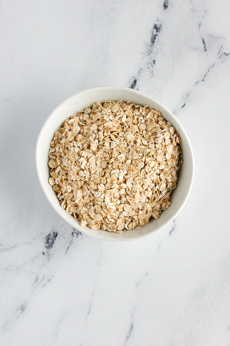 overhead view of quick oats in a white bowl on a marble surface