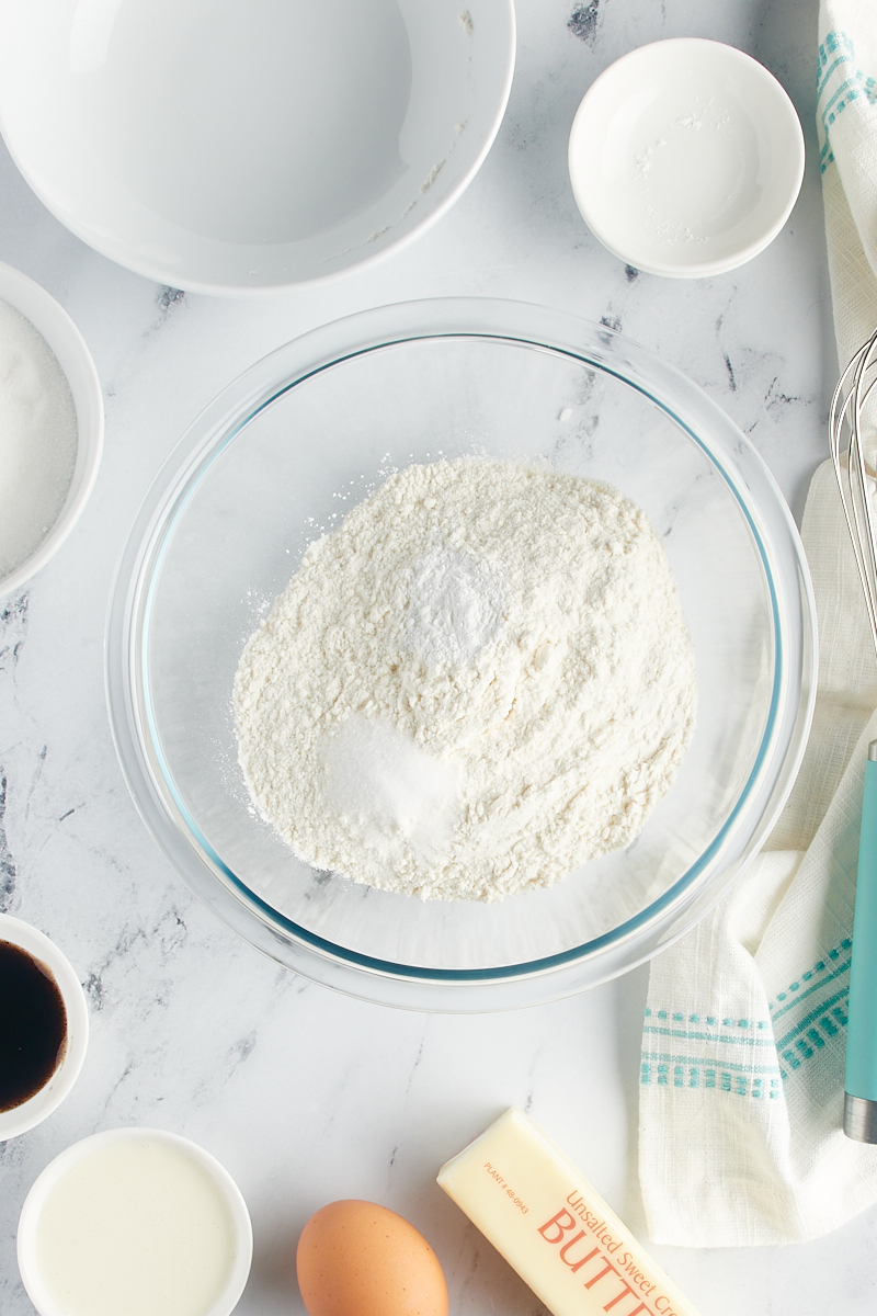 Overhead view of dry ingredients in a glass mixing bowl.