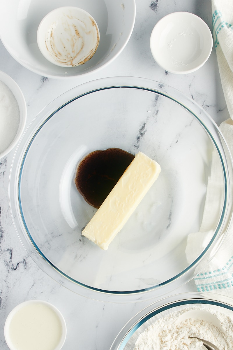 Overhead view of vanilla and a stick of butter in a bowl.