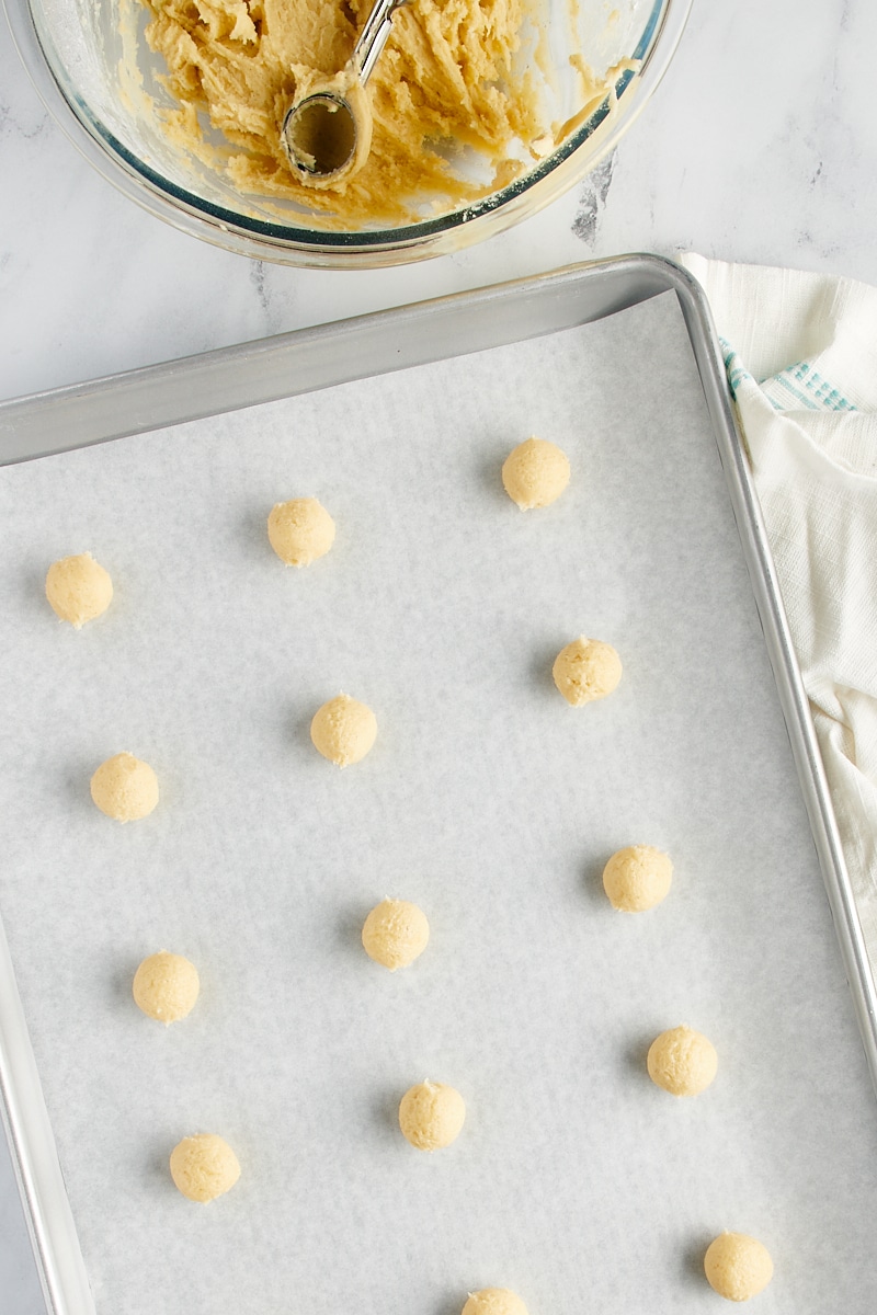 Overhead view of dough balls on a baking sheet.