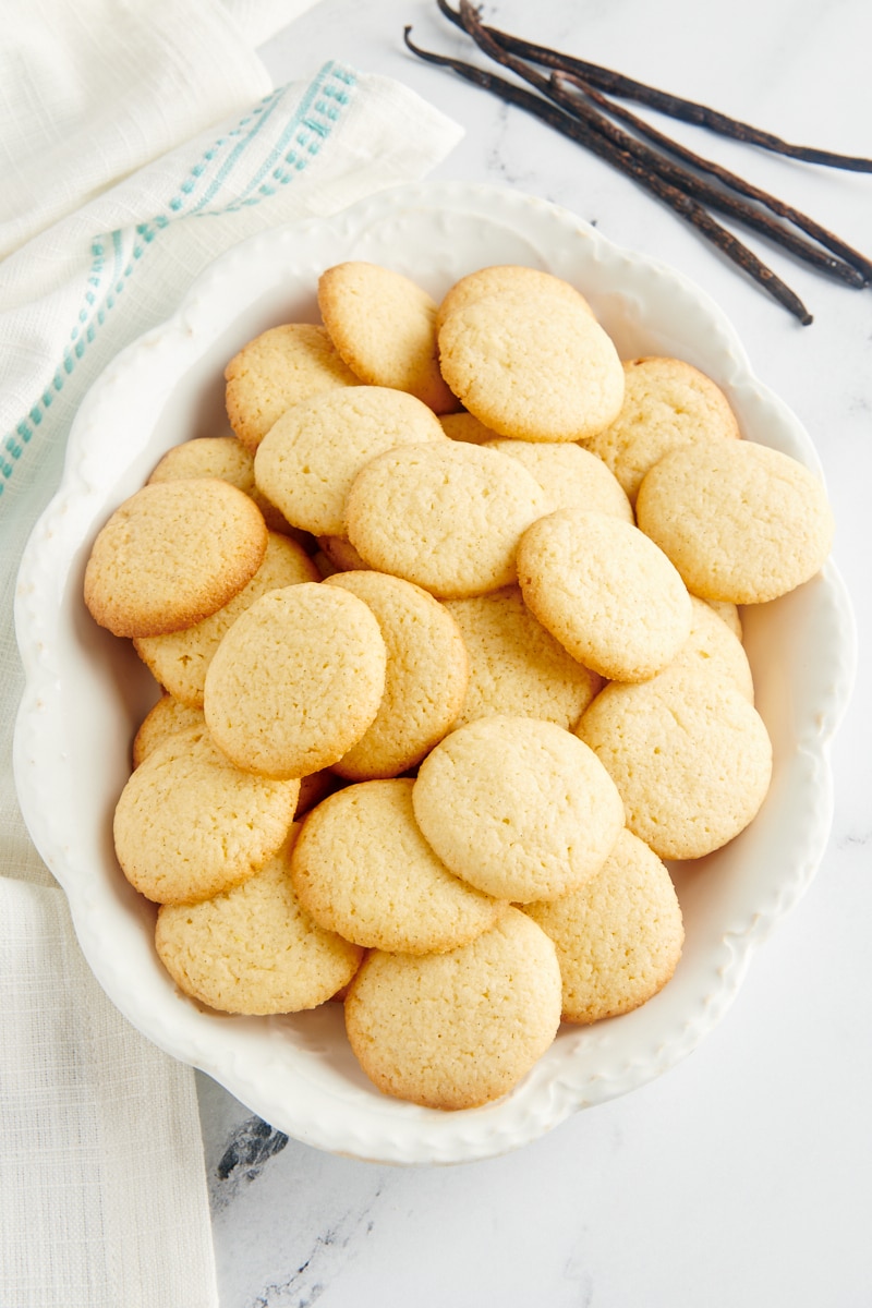 Overhead view of vanilla wafers on a serving platter with vanilla beans in the background.