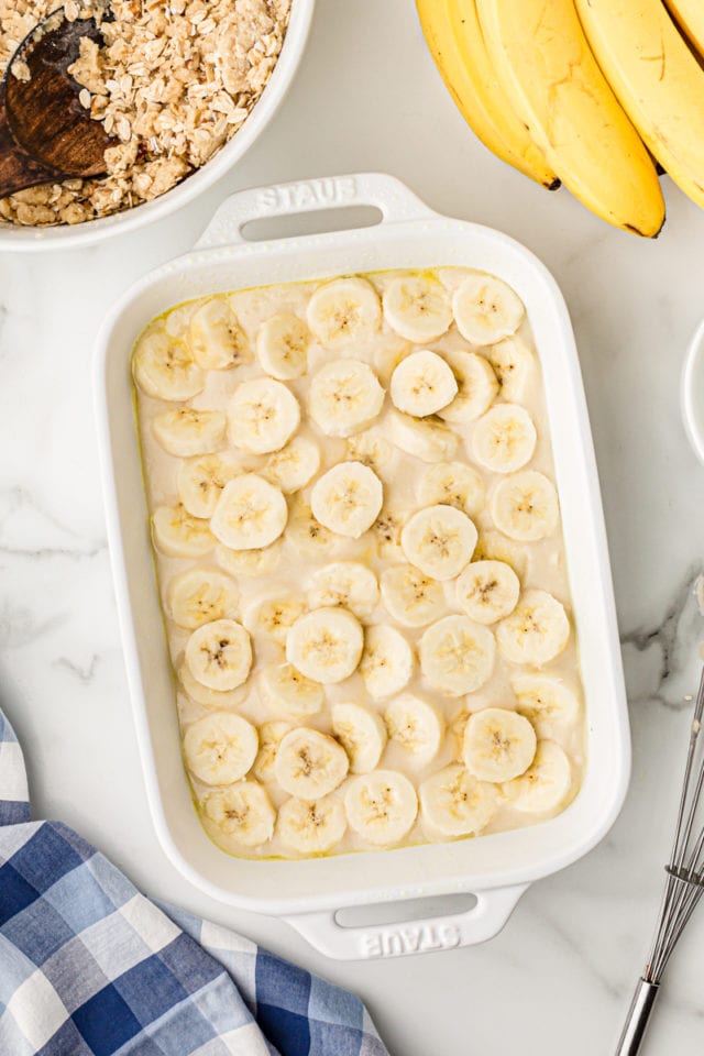 Overhead view of sliced bananas layered in baking dish for cobbler