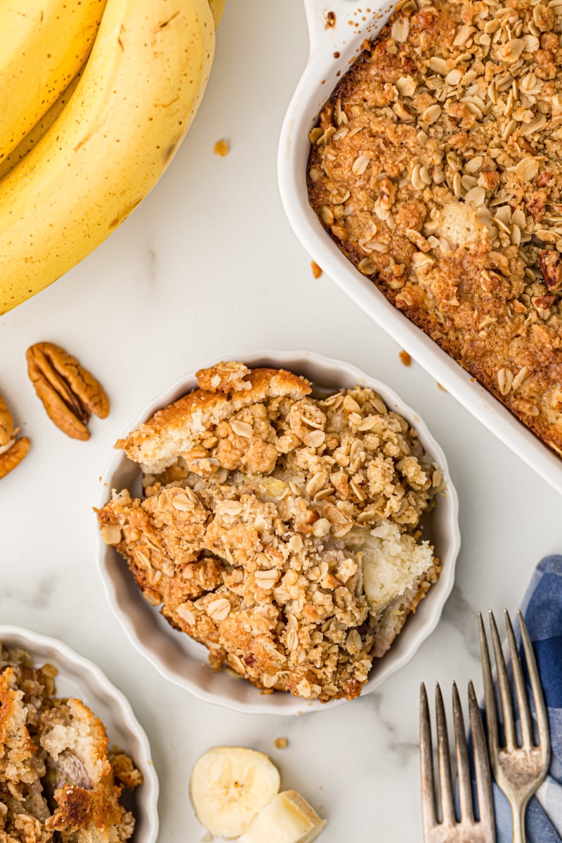 Overhead view of banana bread cobbler in baking dish and bowls