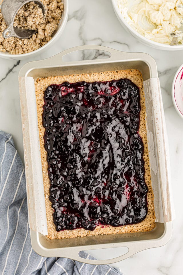 Overhead view of blueberry jam spread over crust in pan