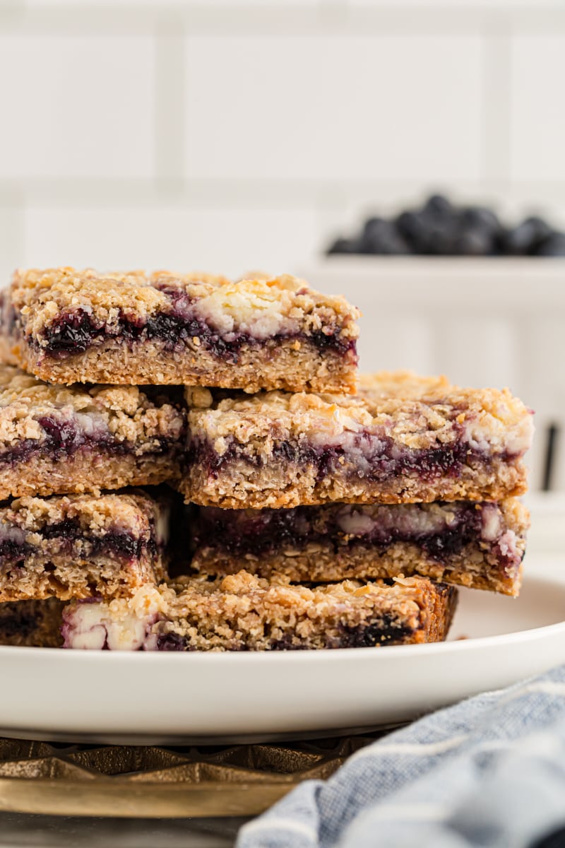 Stack of blueberry jam cream cheese bars on white plate