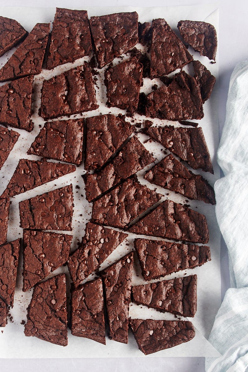 Overhead view of broken brownie brittle on parchment paper