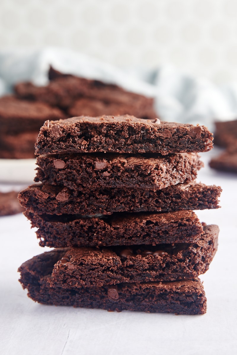 Stack of 6 pieces of brownie brittle, with additional pieces in background
