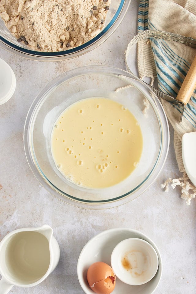 Overhead view of liquid ingredients for scones in glass mixing bowl