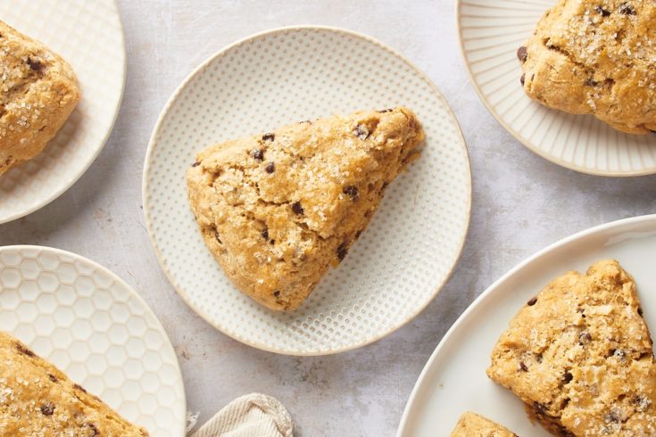 Overhead view of chocolate chip-hazelnut scones on patterned white plates