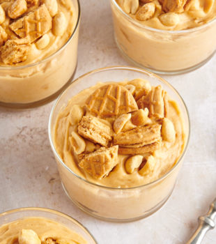 Peanut Butter Mousse served in clear glasses and topped with peanut butter cookies and peanuts