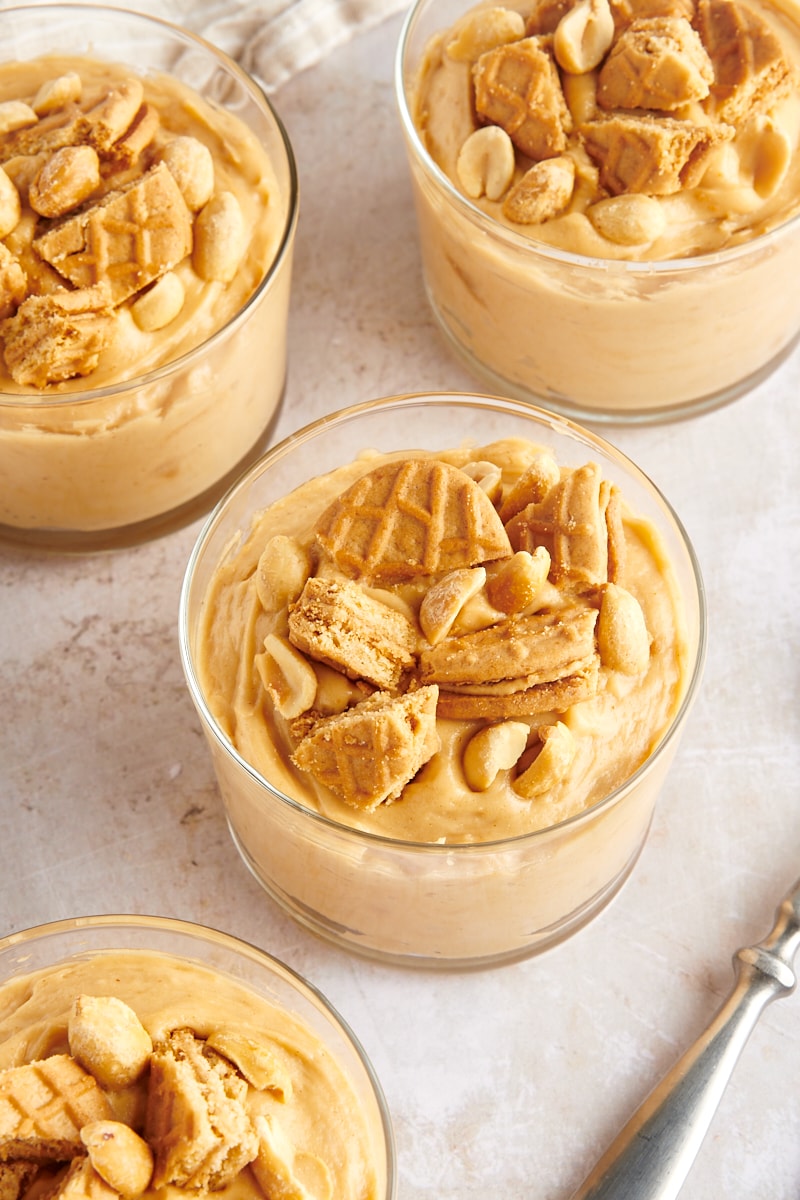 Peanut Butter Mousse served in clear glasses and topped with peanut butter cookies and peanuts