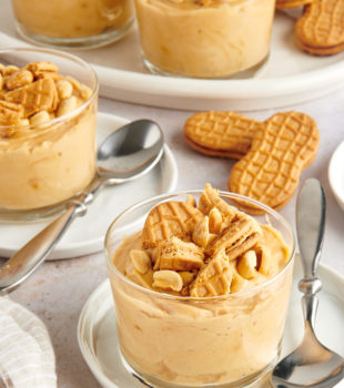 servings of Peanut Butter Mousse in clear glasses topped with peanuts and cookie pieces