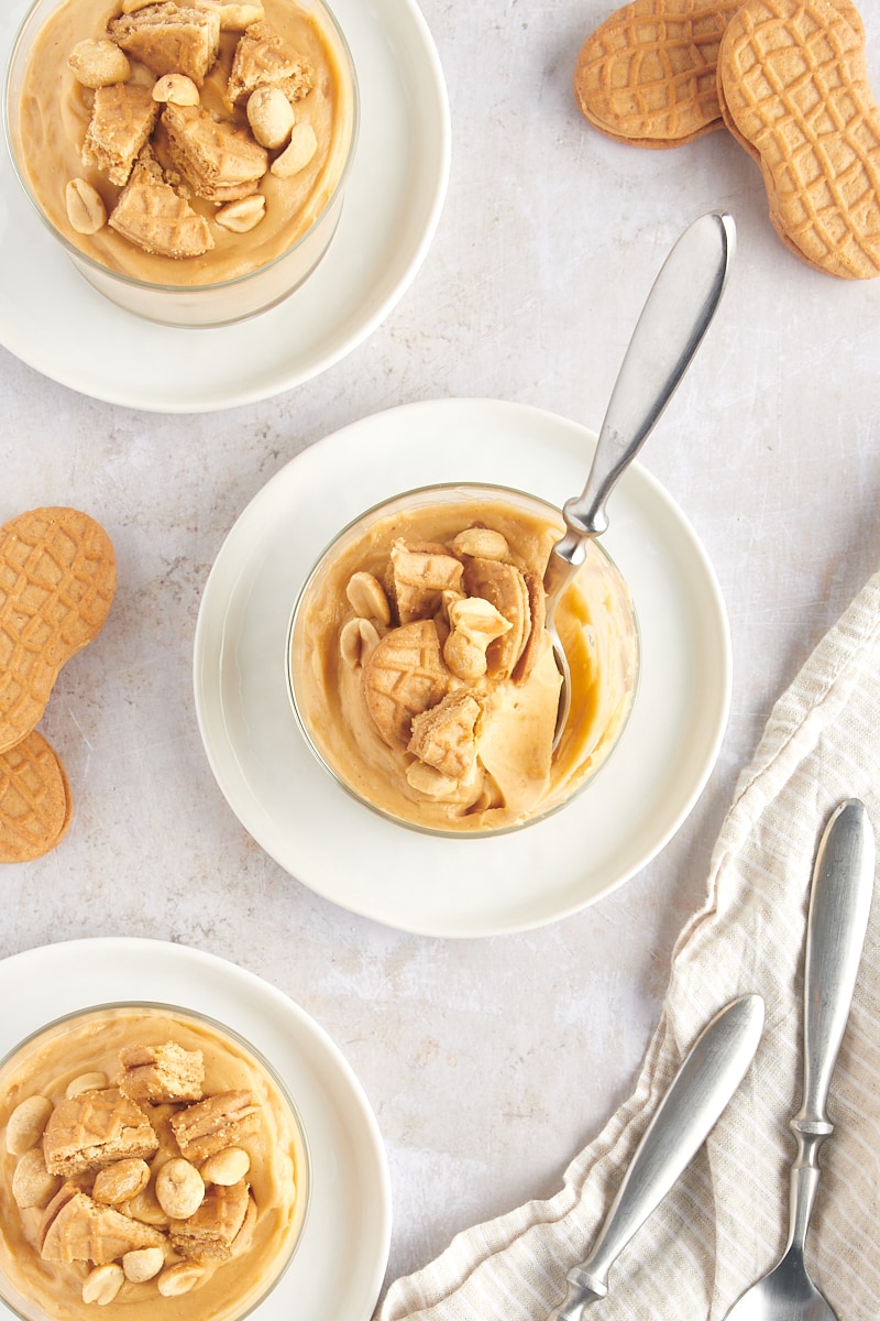 overhead view of three servings of Peanut Butter Mousse in glasses on white plates