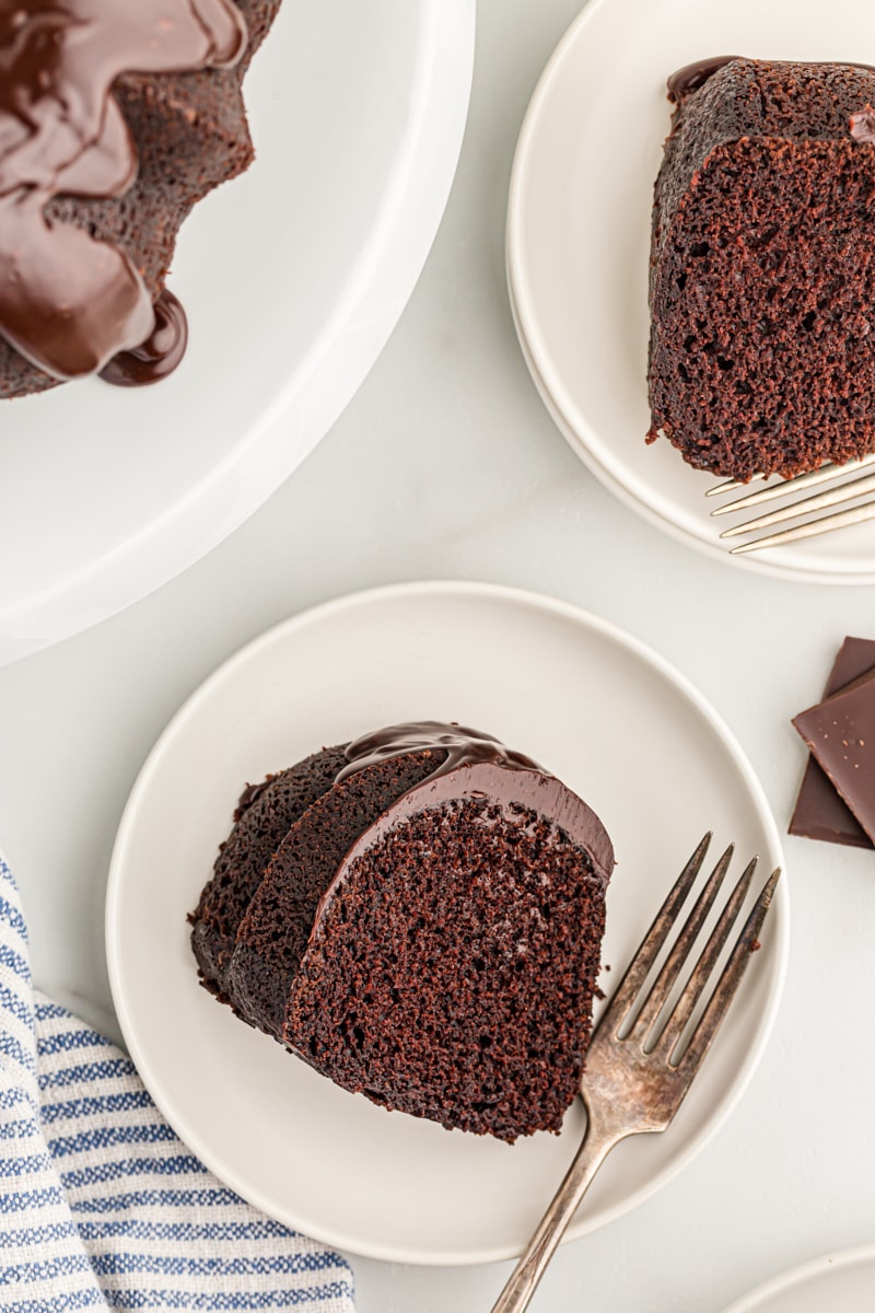 Overhead view of two slices of chocolate sour cream Bundt cake on white plates