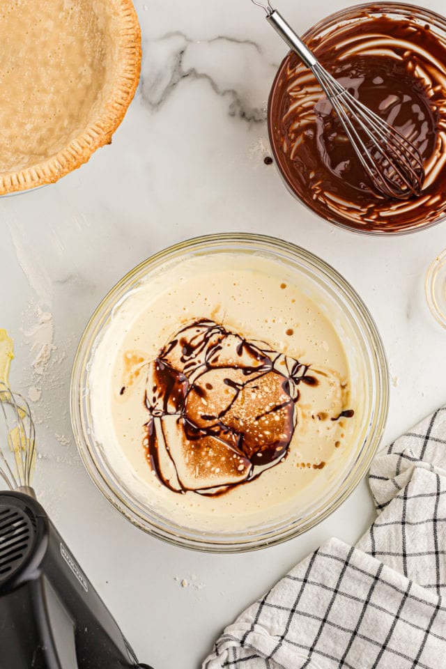 Overhead view of melted chocolate drizzled over bowl of filling ingredients