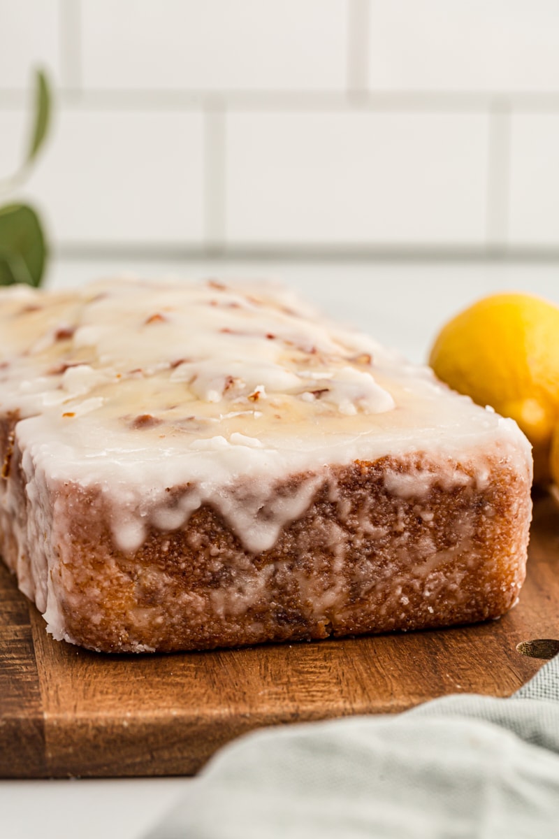 Glazed lemon bread on wood cutting board