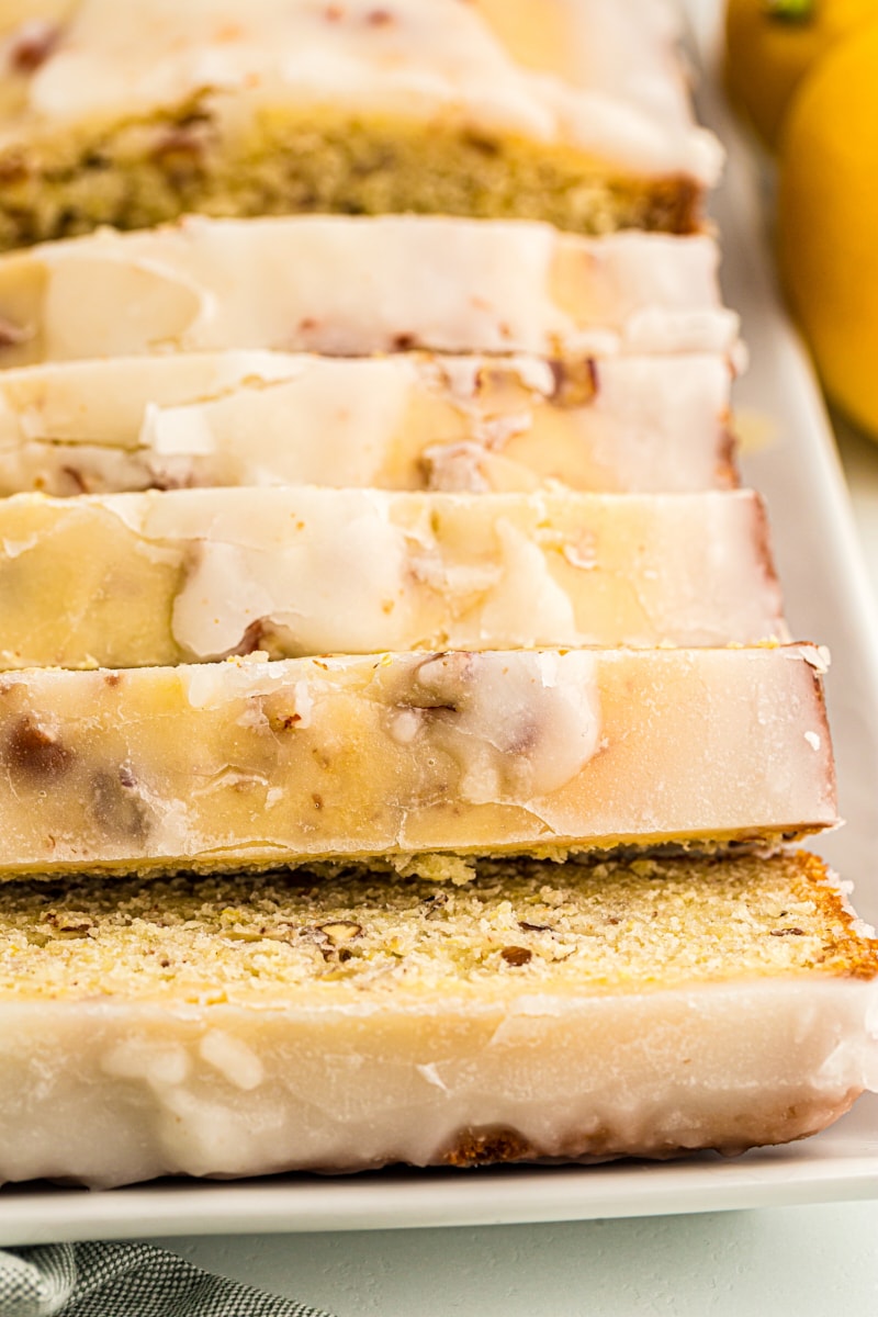 Sliced glazed lemon bread on white serving platter