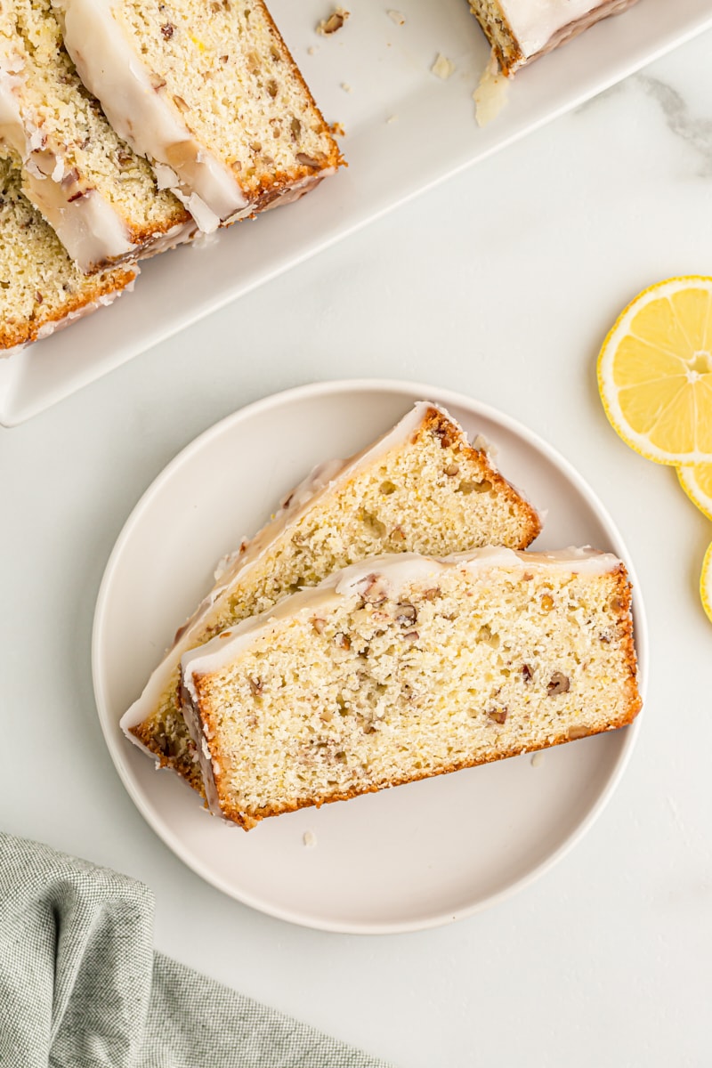 Overhead view of two slices of lemon bread on white plate