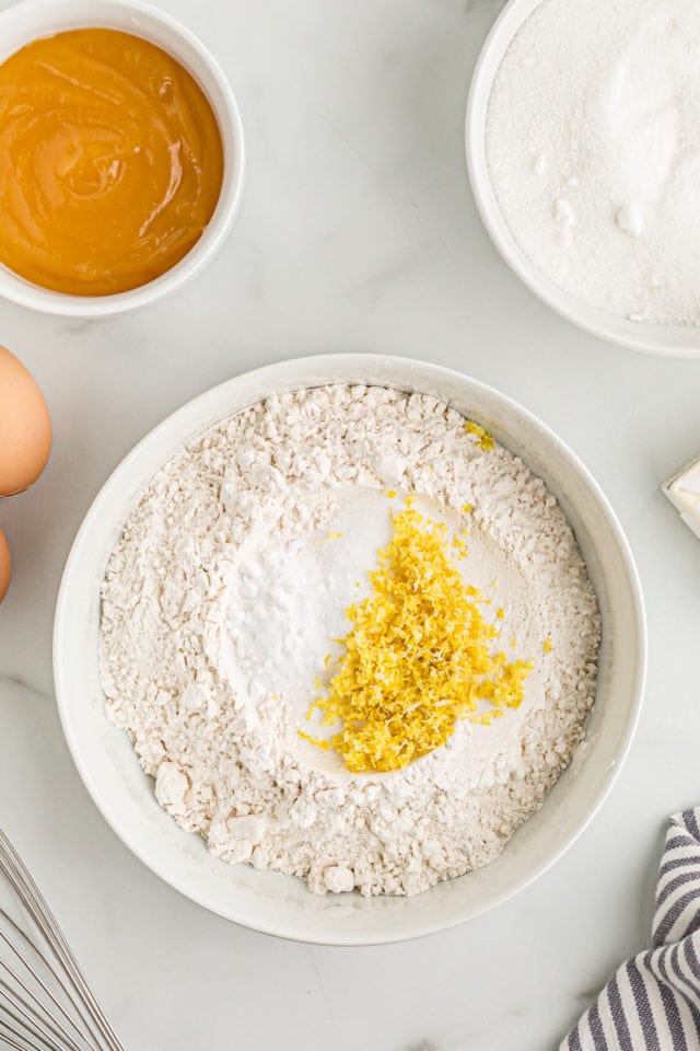 Overhead view of lemon zest and dry ingredients in mixing bowl