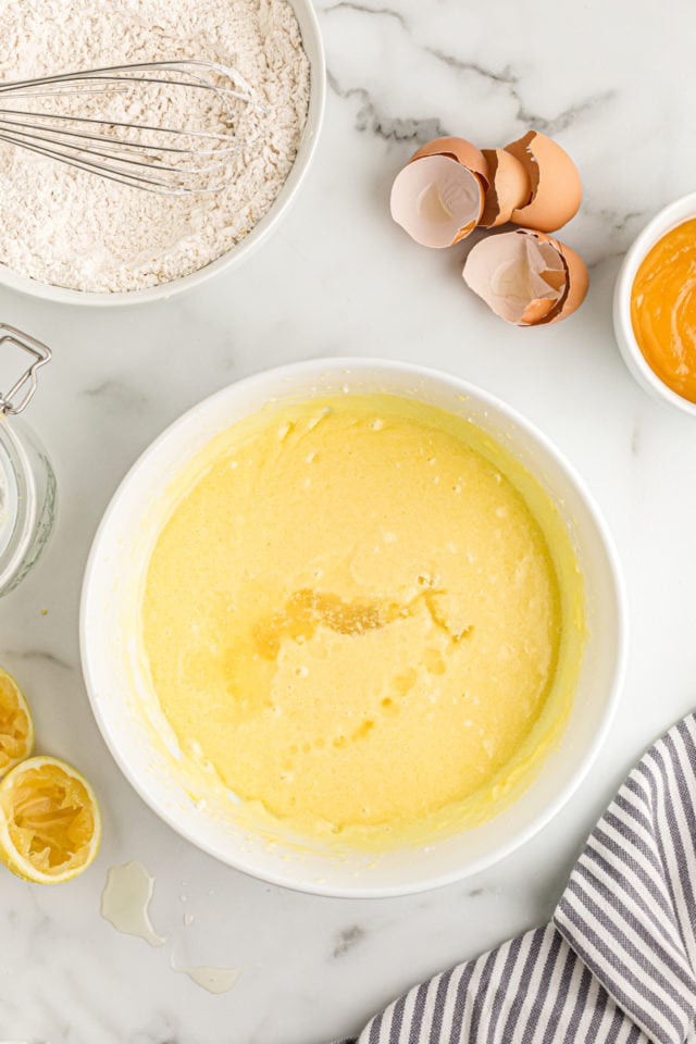 Overhead view of wet ingredients for lemon cream cake in mixing bowl